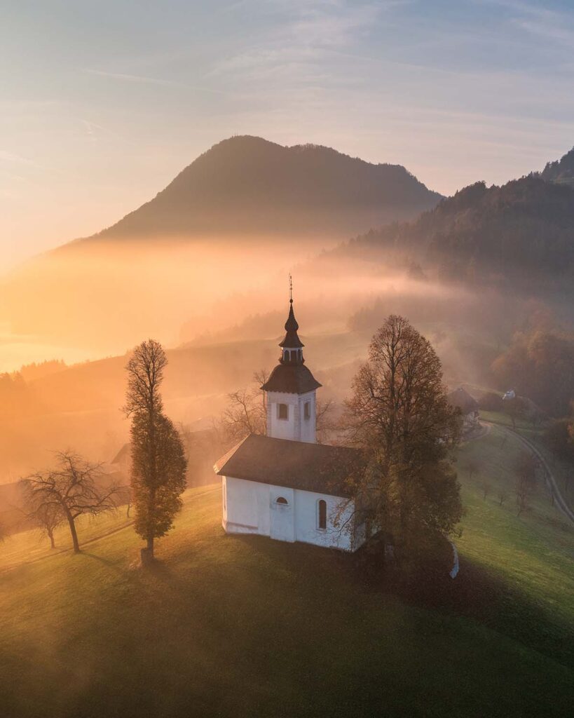 aerial-view-of-small-church-on-the-hill-in-low-clo-VKTRDEK.jpg
